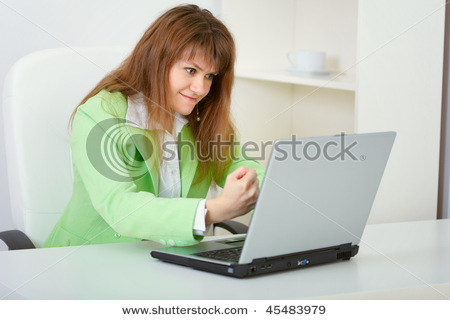 stock_photo_funny_woman_threatened_with_a_fist_to_his_computer_45483979.jpg