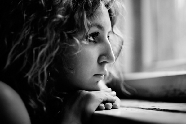 sad_woman_looking_out_dark_window.jpg