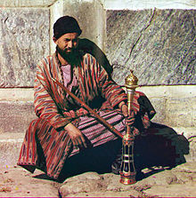 220px_Man_sitting_and_holding_a_hookah.jpg