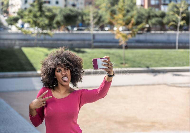 attractive_afro_haired_brunette_woman_takes_selfie_sticking_out_her_tongue_attractive_brunette_woman_takes_selfie_235854024.jpg
