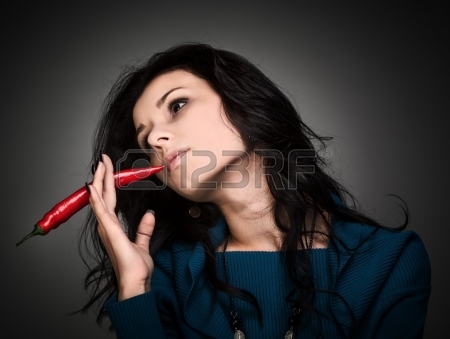 17851923_young_lady_holding_red_hot_chilli_pepper_in_mouth.jpg
