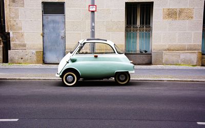 small_car_on_street_against_building_561339047_59cd98f1aad52b0011900cc3.jpg