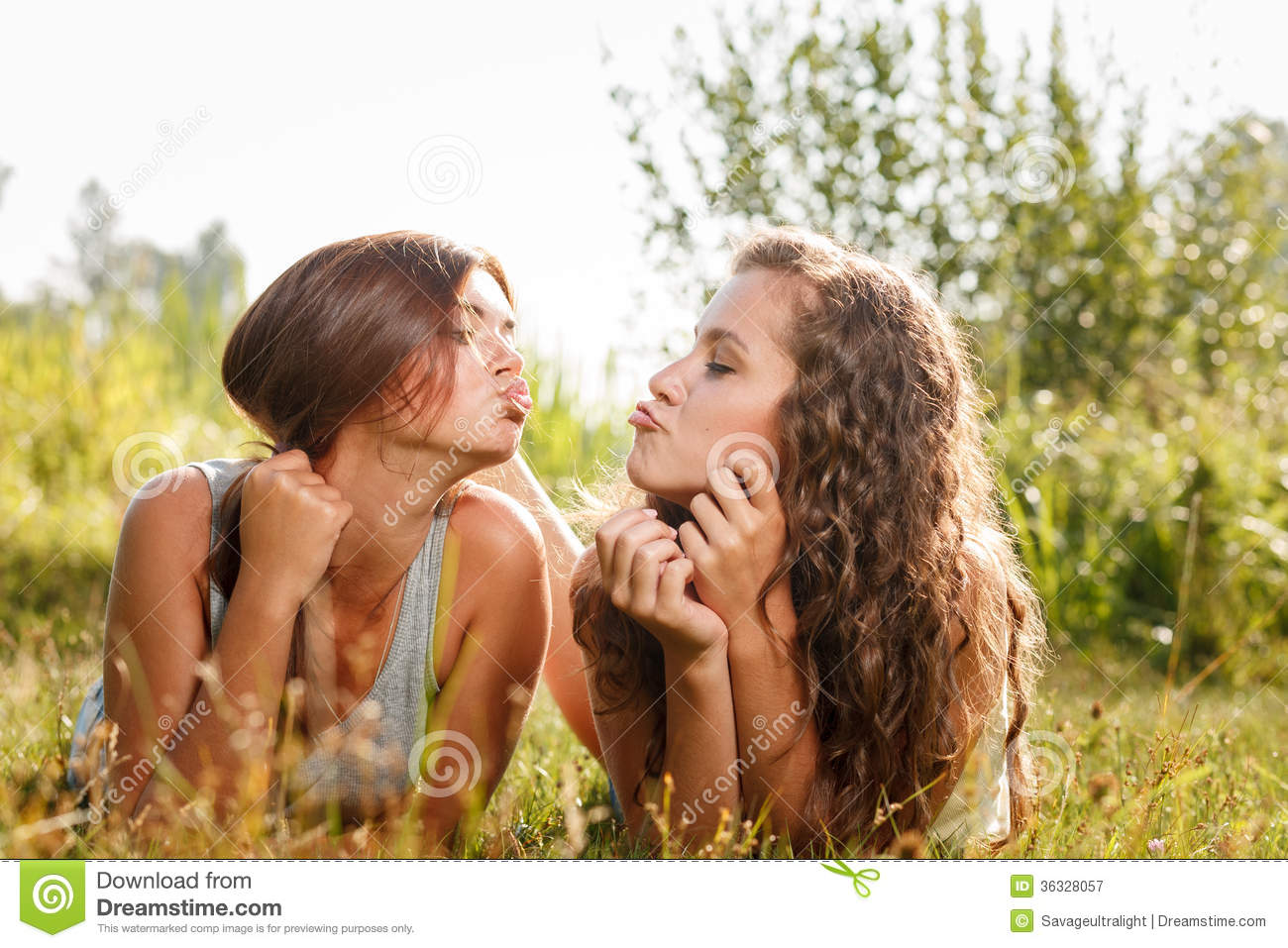 two_girlfriends_lying_down_grass_sending_kiss_36328057.jpg