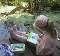 girl_drawing_on_marsh_boardwalk.jpg