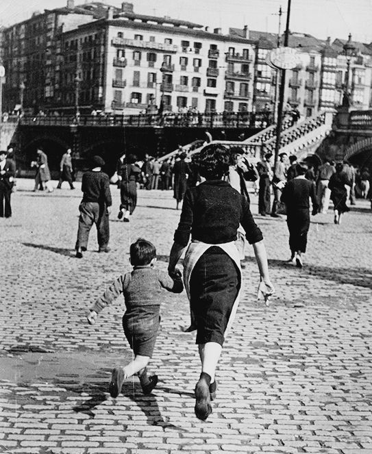 Robert_Capa__Woman_and_child_run_after_an_alarm_has_sounded__Bilbao__1937..jpg