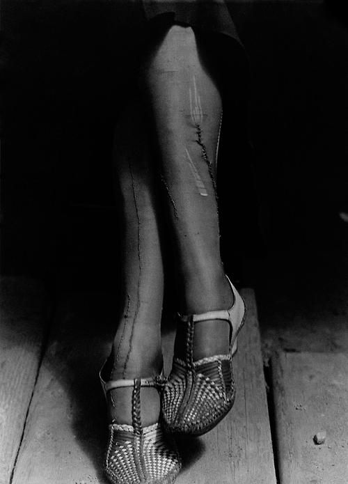 Dorothea_Lange__A_Sign_of_the_Times___Depression___Mended_Stockings___Stenographer__San_Francisco__1934.jpg