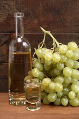 3491246_345018_open_bottle_of_grappa_near_wineglass_and_bunch_of_grapes_against_old_wooden_background.jpg