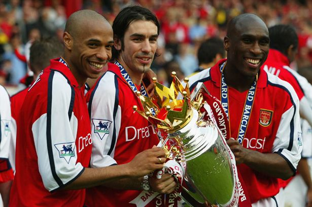 March_2002__Thierry_Henry__Robert_Pires_and_Sol_Campbell_of_Arsenal_celebrate_winning_the_league_at_Highbury_against_Everton.jpg